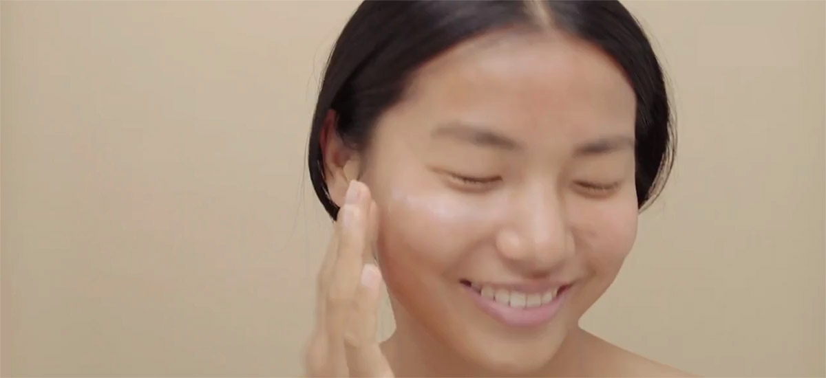 young woman applying face cream